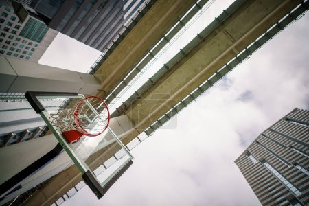 Téléchargez les photos : Vue en angle bas d'un filet de basket sous le chemin de fer dans la ville - en image libre de droit