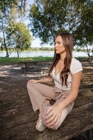 Foto de Mujer sentada en una mesa meditando. Imagen tomada con flash y luz natural mezclada - Imagen libre de derechos