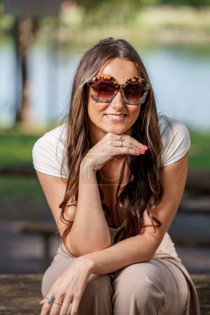 Foto de Mujer joven de moda posando con gafas de sol de gran tamaño - Imagen libre de derechos