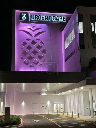 Téléchargez les photos : Plantation, FL, États-Unis - 17 mars 2023 : Baptist Urgent Care hospital in Plantation FL neon purple la nuit - en image libre de droit