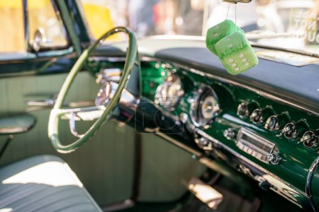 Téléchargez les photos : Dés flous suspendus au miroir dans une voiture américaine classique - en image libre de droit
