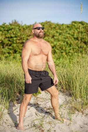 Photo for Macho guy on the beach with sunglasses on the weekend - Royalty Free Image