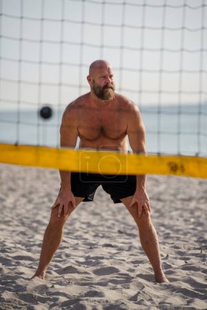 Téléchargez les photos : Homme jouant au volley-ball sur la plage - en image libre de droit