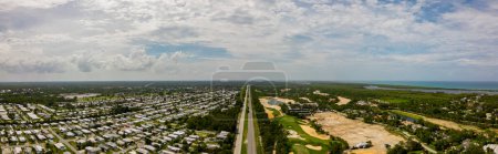 Téléchargez les photos : Photo aérienne par drone des voies ferrées séparant le quartier de la classe supérieure du parc à roulottes Hobe Sound en Floride - en image libre de droit