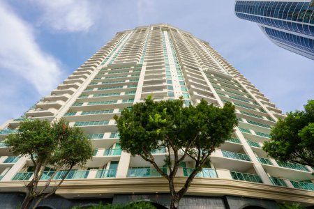 Photo for Low angle view of a high rise building with plush green trees in foreground - Royalty Free Image
