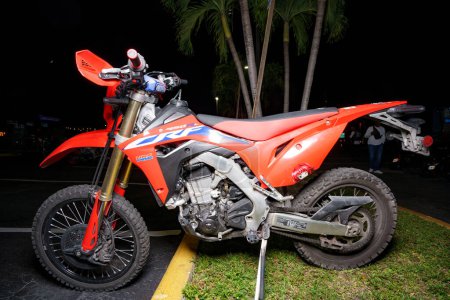Foto de Fort Lauderdale, FL, Estados Unidos - 18 de octubre de 2023: Foto flash nocturna de una moto de motocross Honda roja - Imagen libre de derechos