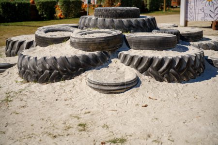 Téléchargez les photos : Vieux pneus sur une aire de jeux pour enfants bac à sable - en image libre de droit