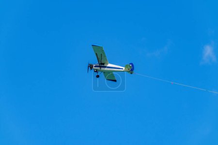 Werbebanner Flugzeug auf blauem Himmel mit sichtbarem Seil