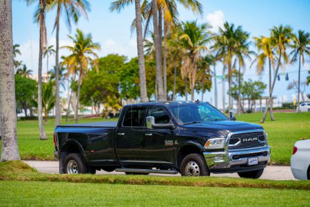 Foto de West Palm Beach, FL, Estados Unidos - 24 de marzo de 2024: Black Ram 3500 pick up truck parking by a grass field - Imagen libre de derechos