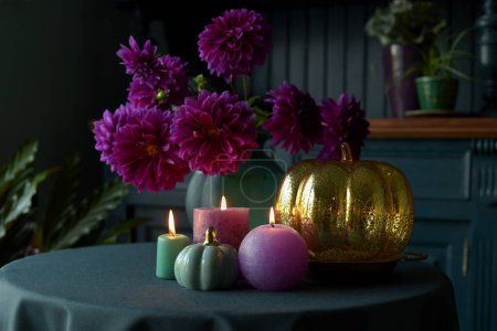 Foto de Hermosas Dalias y calabazas en la mesa, decoración de otoño de Acción de Gracias con velas y calabazas en casa - Imagen libre de derechos