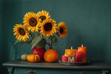 Foto de Hermosos girasoles y calabazas en la mesa, decoración de otoño con velas y calabazas - Imagen libre de derechos