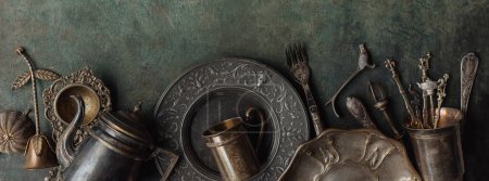 Photo for Antique silver and bronze cutlery and crockery on an old background;  Silver flatware. Kitchen utensils - Royalty Free Image