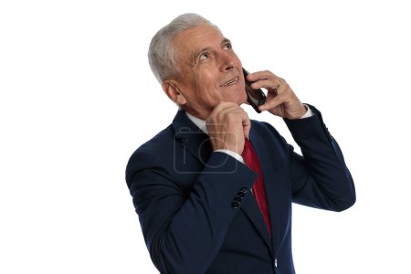 Foto de Businessman talking on the phone while scratching his chin and thinking about something - Imagen libre de derechos