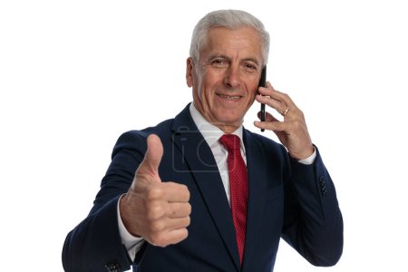 Téléchargez les photos : Businessman talking on the phone and giving a like - en image libre de droit