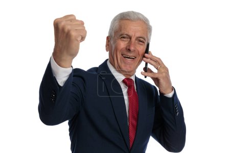 Photo for Businessman talking on the phone while celebrating success and smiling wide - Royalty Free Image