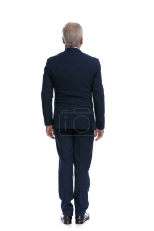Téléchargez les photos : Full body picture and rear view of an old businessman standing and wearing a suit - en image libre de droit