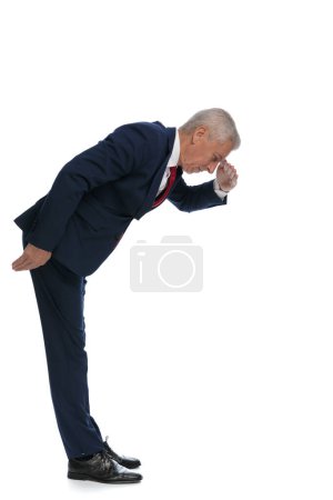 Photo for Full body picture and side view of an old businessman protecting his eyes so he can see better what's down there - Royalty Free Image