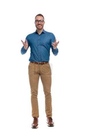 Photo for Nerd guy with glasses being happy, smiling and gesturing in front of white background in studio - Royalty Free Image