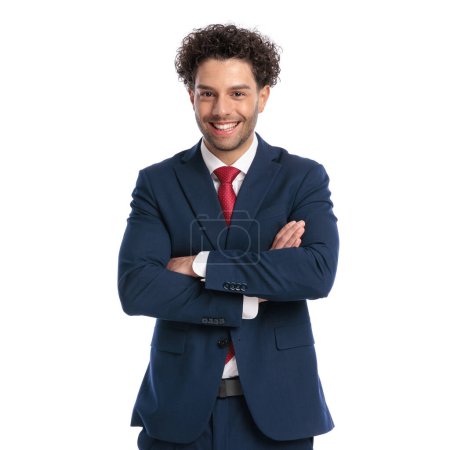 Foto de Portrait of elegant businessman with curly hair folding arms and smiling in front of white background in studio - Imagen libre de derechos