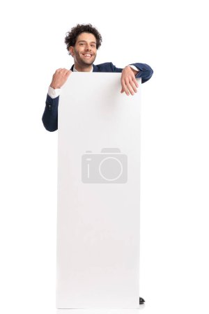 Foto de Excited turkish man showing and presenting white empty board on white background - Imagen libre de derechos