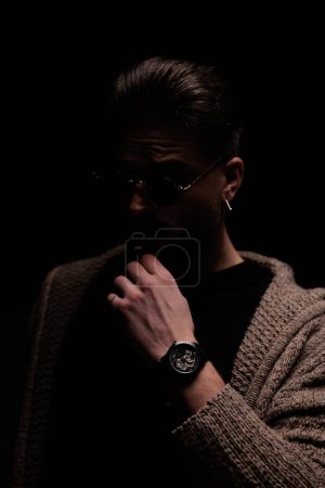 Photo for Portrait of attractive fashion model scratching his chin and looking away, standing, in a fashion pose - Royalty Free Image