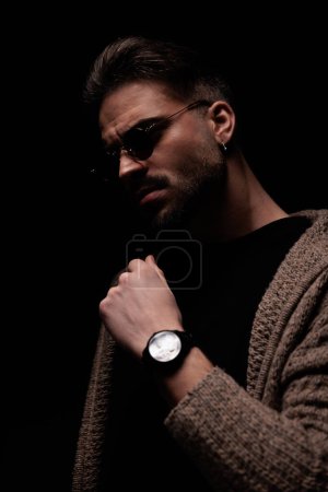 Photo for Portrait of young guy looking away and fixing his coat, standing, in a fashion pose - Royalty Free Image