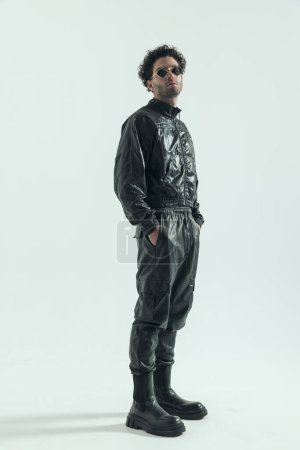 Photo for Attractive casual man putting hands in pocket, wearing a leather costume in a fashion pose - Royalty Free Image
