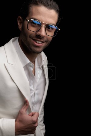 Foto de Recorte de imagen de hombre joven feliz con gafas haciendo pulgares hacia arriba signo y sonriendo delante de fondo negro - Imagen libre de derechos