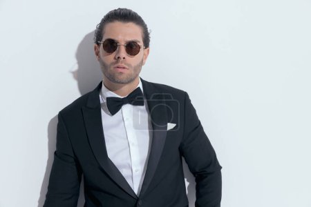 Téléchargez les photos : Homme d'affaires attrayant avec un beau style regardant la caméra, portant des lunettes sur fond de studio blanc - en image libre de droit