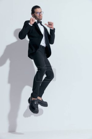 Photo for Handsome businessman jumping an pointing to himself with pride, wearing glasses against white studio background - Royalty Free Image