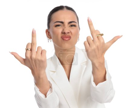 Photo for Portrait of vulgar elegant woman making a face and showing middle fingers as an obscene gesture in front of white background - Royalty Free Image