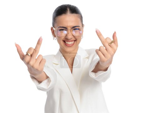 Foto de Mujer elegante excitada con gafas mostrando el dedo medio y riendo delante de fondo blanco - Imagen libre de derechos