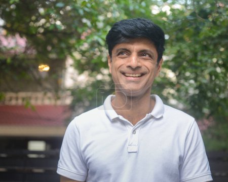 Téléchargez les photos : Un homme indien intelligent d'âge moyen en t-shirt blanc à l'extérieur - en image libre de droit