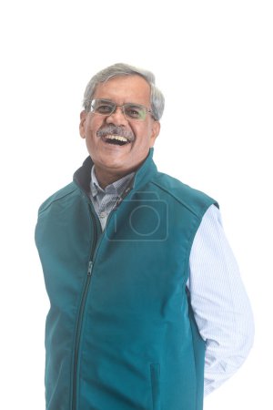 Téléchargez les photos : Un homme d'affaires indien senior souriant ou un cadre avec les cheveux gris dans une chemise bleu clair et costume vert sans manches isolé sur blanc - en image libre de droit