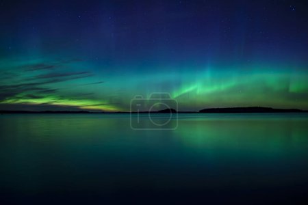Photo for Scenic view of northern lights over calm lake in Sweden (Aurora borealis) - Royalty Free Image