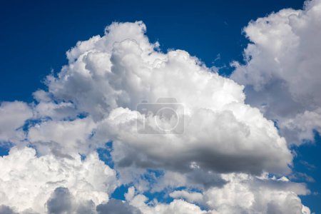 Himmel mit flauschigen Wolken vor blauem Hintergrund