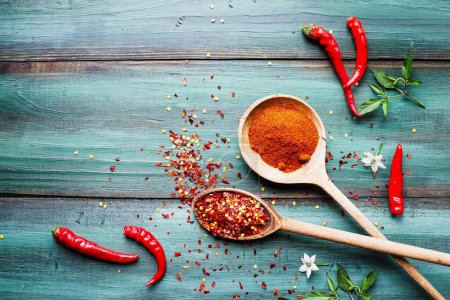 Photo for Red hot spicy cayenne and serrano peppers, both fresh and dried seeds, in wooden spoon. Flat lay over rustic background. - Royalty Free Image