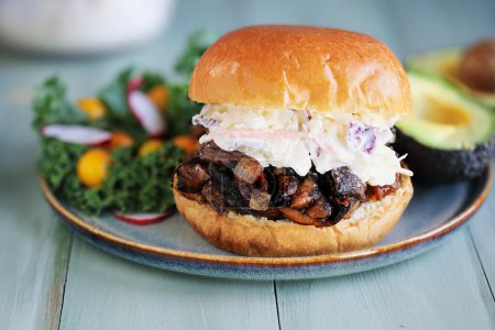 Photo for Vegan and vegetarian pulled portobello mushroom burger with slaw. Made with mushrooms, onions, and homemade bbq sauce on a fresh brioche bun used an a substitute for pulled chicken, pork or beef. - Royalty Free Image