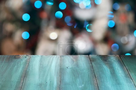 Photo for Rustic painted green table with beautiful blurred Christmas tree lights and bokeh in the background Christmas. - Royalty Free Image