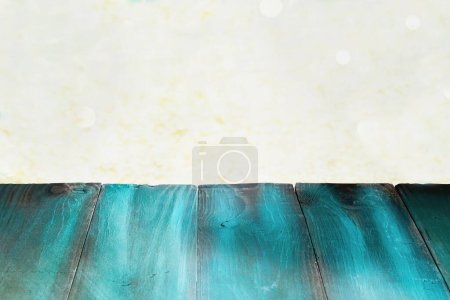 Photo for Rustic painted green table with beautiful gold Christmas bokeh. Free space for text. - Royalty Free Image