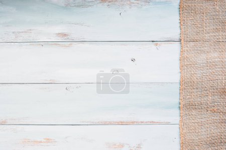 Photo for Table top view of bright blue and white wooden texture background with burlap banner. Image shot from overhead view. - Royalty Free Image