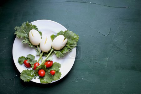 Photo for Fun, colorful creative boiled egg tulip flowers for children with cherry tomatoes for Easter eggs and kale for leaves to encourage kids to eat healthy foods. - Royalty Free Image