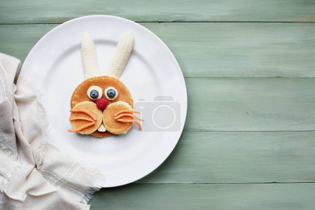 Photo for Fun, colorful creative pancake bunny rabbit for children with banana, blueberries, carrots and raspberries to encourage kids to eat healthy foods. - Royalty Free Image