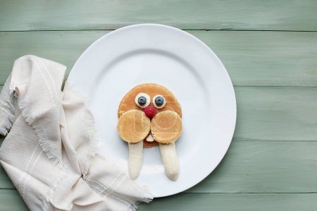 Photo for Fun, colorful creative pancake walrus for children with banana, blueberries and raspberries to encourage kids to eat healthy foods. - Royalty Free Image