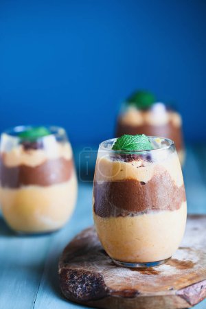 Photo for Delicious vegan mango chocolate pudding garnished with mint leaves. Selective focus with blurred background. - Royalty Free Image
