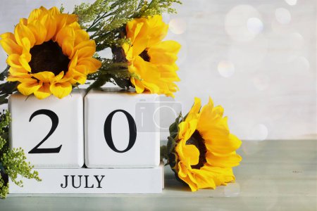 Photo for International Chess Day. White wood calendar blocks with the date July 20th and beautiful sunflower bouquet with bokeh. Selective focus with blurred background. - Royalty Free Image