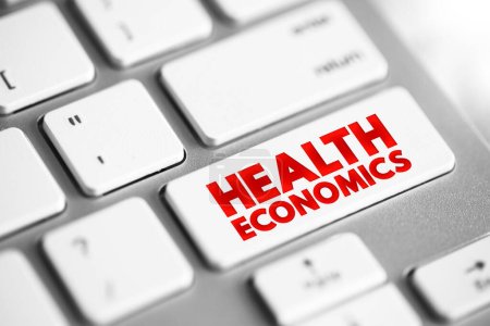 Téléchargez les photos : Économie de la santé est une branche de l'économie concernée par les questions liées à la production et la consommation de la santé et de la santé, bouton de concept de texte sur le clavier - en image libre de droit