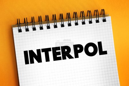 Téléchargez les photos : Interpol - organisation internationale qui facilite la coopération policière mondiale et le contrôle de la criminalité, concept de texte sur bloc-notes - en image libre de droit