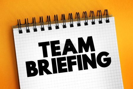 Team Briefing is a process which involves managers talking to their teams to exchange information and ideas, text concept on notepad