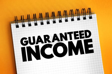 Guaranteed Income - social-welfare system that guarantees all citizens or families an income sufficient to live on, text concept on notepad